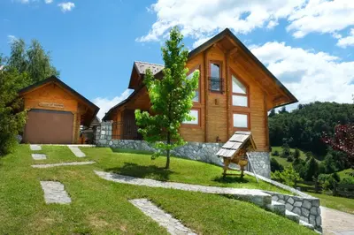 a house on a hill with a sign in front of it at House of Nature Tajhte in Planina pri Sevnici