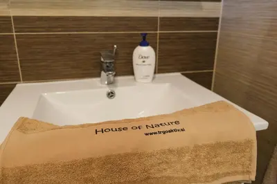 a bathroom sink with a house of nene sign on it at House of Nature Tajhte in Planina pri Sevnici