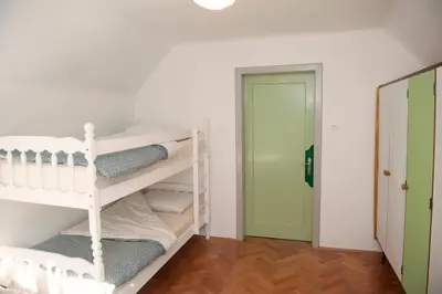 a room with white bunk beds and a green door at Apartment Polane in Blejska Dobrava