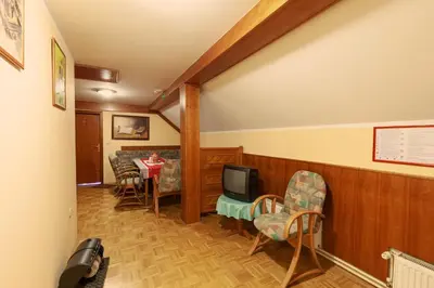 a living room with a tv and a table and chairs at Gostišče Prosnik in Ormoz