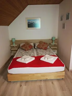 a bedroom with a large bed with two towels on it at Apartma Lip in Rateče