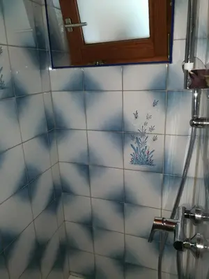 a bathroom with blue and white tiles and a mirror at Apartma Lip in Rateče