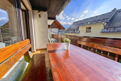 a wooden table on the balcony of a house at Castle way Apartments Tamy in Bled