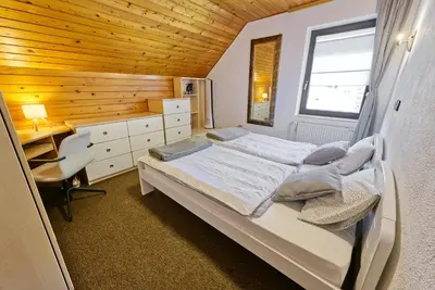 a bedroom with a bed and a desk and a window at Castle way Apartments Tamy in Bled