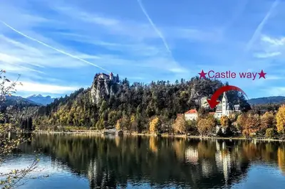 a kite flying over a lake in the mountains at Castle way Apartments Tamy in Bled