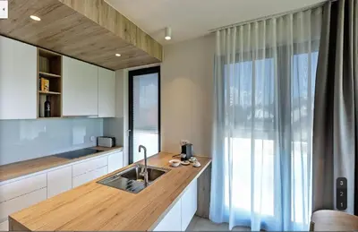 a kitchen with a wooden counter with a sink at Regentova Suites Ljubljana in Ljubljana