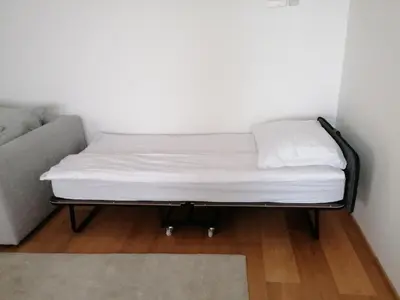 a bed in a room next to a couch at Regentova Suites Ljubljana in Ljubljana