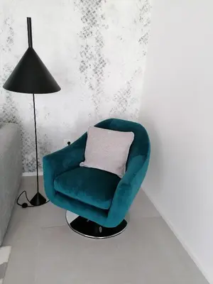 a green chair in a room with a lamp at Regentova Suites Ljubljana in Ljubljana