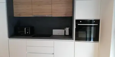 a white kitchen with white cabinets and appliances at Regentova Suites Ljubljana in Ljubljana