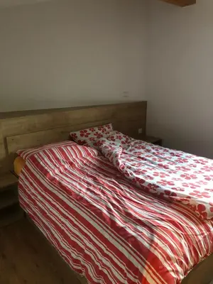a bed with a red and white comforter on it at BC10 in Bovec