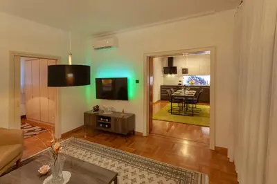 a living room with a couch and a television and a table at Villa Magnolia in Ljubljana