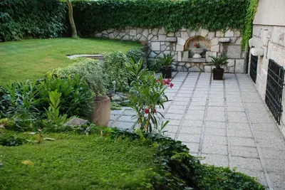 a garden with plants and a stone wall at Villa Magnolia in Ljubljana