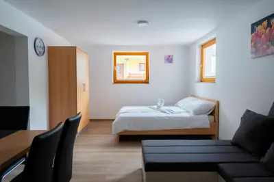 a small bedroom with a bed and a couch at PJagodic Apartments & Wellness in Cerklje na Gorenjskem