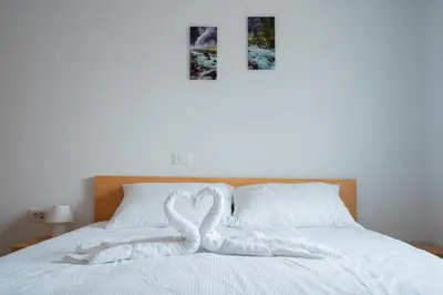 two hearts towels on a bed with two pictures at PJagodic Apartments & Wellness in Cerklje na Gorenjskem