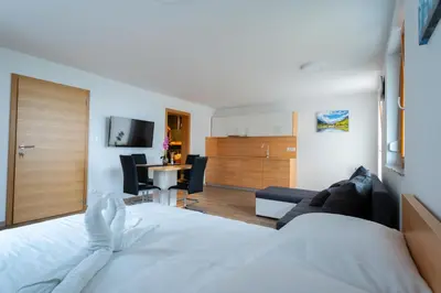a bedroom with a bed and a living room at PJagodic Apartments & Wellness in Cerklje na Gorenjskem