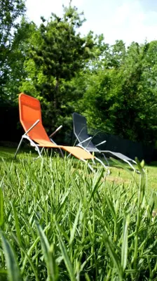 an orange and black chair sitting in the grass at Sunset Bled in Bled