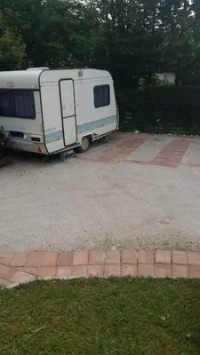 a white trailer parked in a parking lot at ANERI in Ljubljana