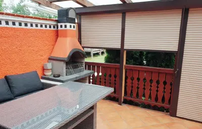 a patio with a table and a fireplace at Aparthouse SUPREME with Terme Catez Swimming Pools Tickets in Čatež ob Savi