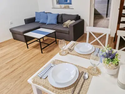 a living room with a table and a couch at Aparthouse SUPREME with Terme Catez Swimming Pools Tickets in Čatež ob Savi