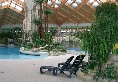 two chairs and a swimming pool in a resort at Aparthouse SUPREME with Terme Catez Swimming Pools Tickets in Čatež ob Savi