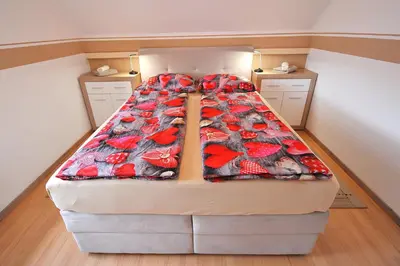 a large bed in a small room with a bedspread at Aparthouse SUPREME with Terme Catez Swimming Pools Tickets in Čatež ob Savi