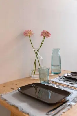 a table with a plate and a vase with flowers at Garden living in Bled