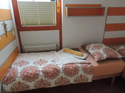 a small bedroom with a bed and a window at Marijin dom - Retreat House in Bled