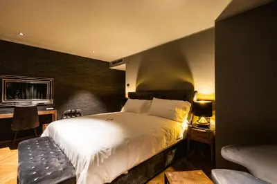 a bedroom with a large white bed and a desk at DAM boutique hotel & restaurant in Nova Gorica