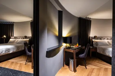 a hotel room with two beds and a table and chairs at DAM boutique hotel & restaurant in Nova Gorica