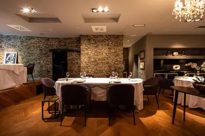a dining room with tables and chairs and a chandelier at DAM boutique hotel & restaurant in Nova Gorica