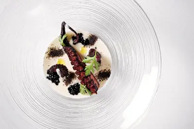 a white plate with a dessert with meat and vegetables at DAM boutique hotel & restaurant in Nova Gorica