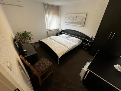 a small bedroom with a bed and a chair at Gostišče pri Slavcu in Šentjernej