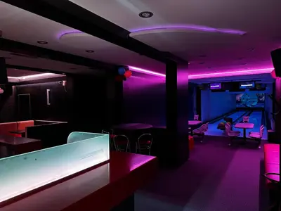 a bar with purple lights and tables and chairs at Gostišče pri Slavcu in Šentjernej