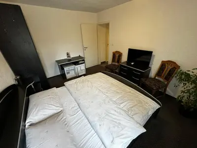 a bedroom with a bed and a desk and a television at Gostišče pri Slavcu in Šentjernej