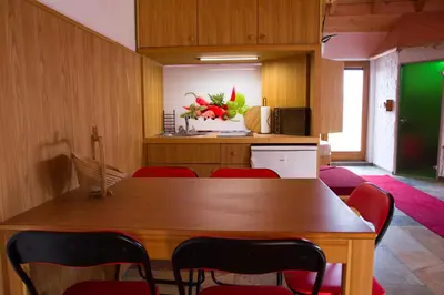 a dining room with a wooden table and red chairs at SECRET WELLNESS in Bodonci