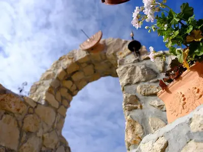 a stone wall with flowers on the side of it at SECRET WELLNESS in Bodonci