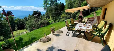 a table and chairs on a patio with a view at Alpinejka House in Tržič