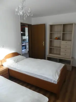 a bedroom with two beds and a chandelier at Apartmaji Baron in Bled