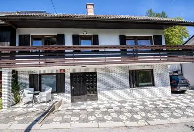 a white brick house with a porch and a patio at Apartmaji Baron in Bled