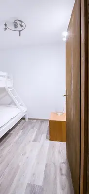 a bedroom with a bed and a wooden door at Apartmaji Baron in Bled