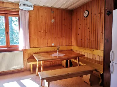 a dining room with a wooden table and benches at Chalet Stara Jelka Pokljuka in Zgornje Gorje