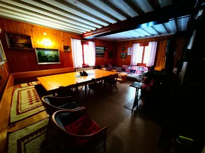 a living room with a wooden table and chairs at Chalet Stara Jelka Pokljuka in Zgornje Gorje