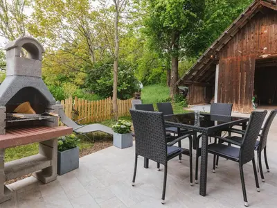 a patio with a table and chairs and a grill at Blue Door in Lesce