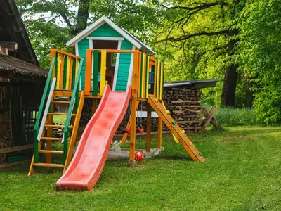 a playground with a slide and a play house at Blue Door in Lesce