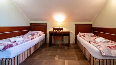 two beds in a room with a table and a desk at VEGANFRESH in Medvode