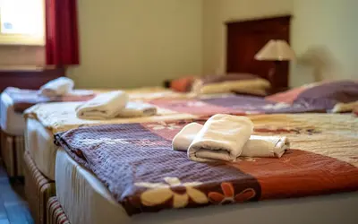 three beds with towels on them in a hotel room at VEGANFRESH in Medvode
