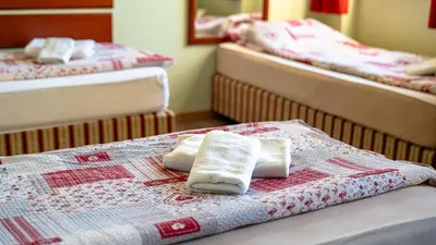 two beds with towels on top of them in a room at VEGANFRESH in Medvode