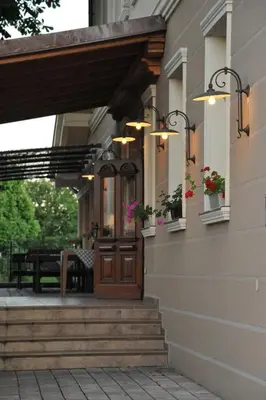 a house with a wooden door and stairs with flowers at VEGANFRESH in Medvode