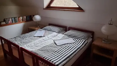 a bedroom with a bed with two pillows and a window at Architect’s house - peaceful and minimalistic in Bled