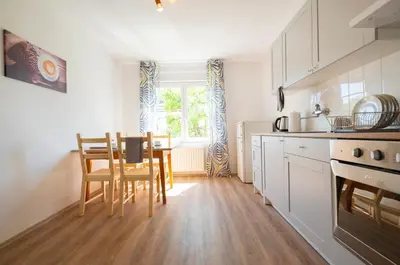 a kitchen with a table and chairs and a window at Apartment Ksenija in Ljubljana